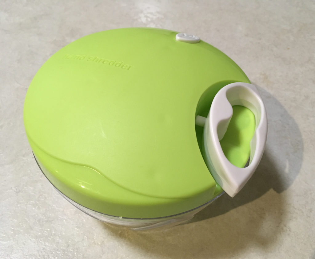 Small manual mini-processor with handle partially pulled out.